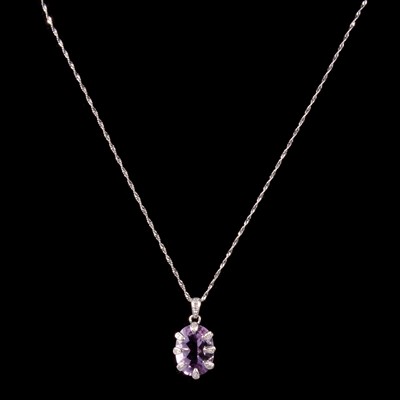 Lot 265 - Two amethyst and diamond pendants on chains.