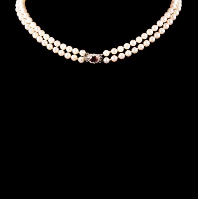 Lot 325 - A two row cultured pearl necklace with garnet and diamond clasp.