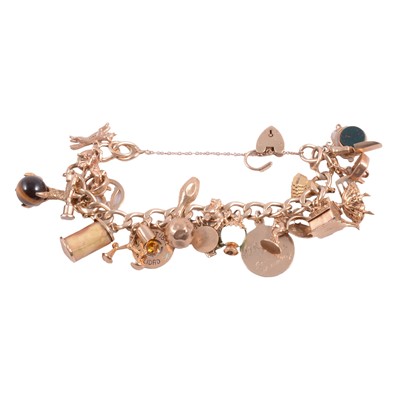 Lot 283A - A 9 carat yellow gold charm bracelet with twenty-six charms attached.