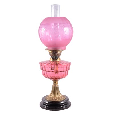 Lot 57 - Cranberry glass and brass oil lamp