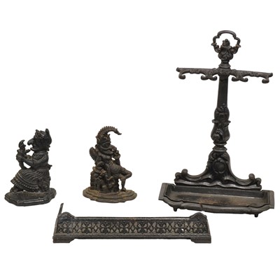 Lot 376 - Victorian cast iron stick stand, Punch & Judy door stops and a small fender