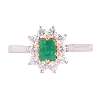 Lot 57 - An emerald and diamond cluster ring.