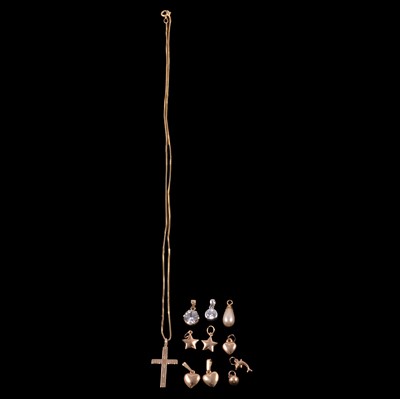 Lot 157 - A gold cross pendant on a chain, seven yellow metal charms, and three pendants.
