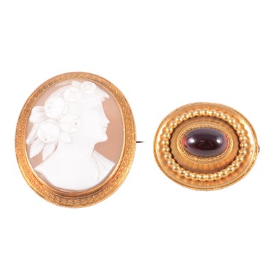 Lot 194 - An oval carved shell cameo brooch, and a red stone target brooch.