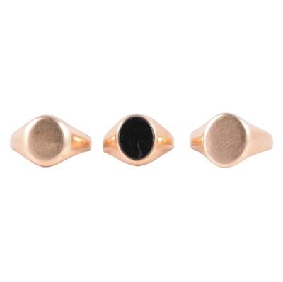 Lot 125 - A yellow metal onyx signet ring, and two gold signet rings.