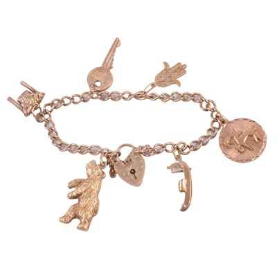 Lot 231 - A 9 carat yellow gold charm bracelet with charms attached.