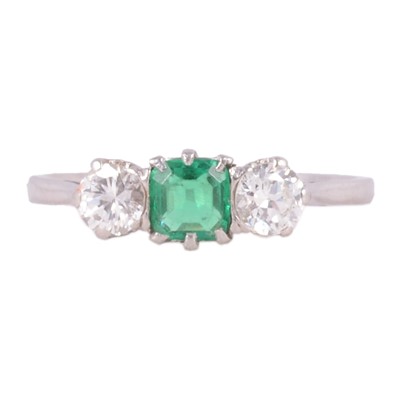 Lot 15 - An emerald and diamond three stone ring.