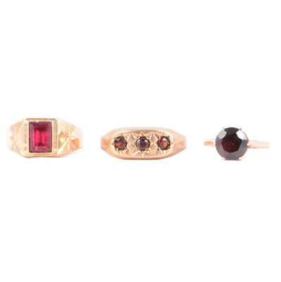 Lot 44 - Two garnet dress rings, and a synthetic pink stone dress ring.