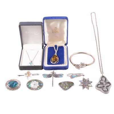 Lot 497 - A collection of modern silver and white metal pendants on chains, bangle, and brooches.
