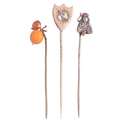 Lot 343 - A paste set stick pin, paste set fly stick pin, and amber-coloured spider stick pin.