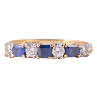 Lot 15 - A sapphire and diamond half eternity ring.