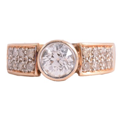Lot 77 - A diamond solitaire ring with diamond shoulders.