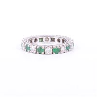 Lot 182 - An emerald and diamond full eternity ring, ten...