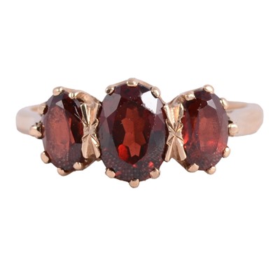 Lot 29 - A garnet three stone ring.