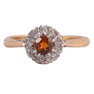 Lot 32 - An orange gemstone and diamond cluster ring.