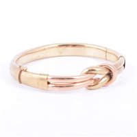 Lot 212 - A yellow metal knot design bangle, 8.5mm wide...