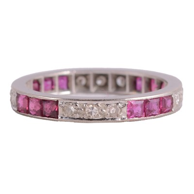Lot 20 - A ruby and diamond full eternity ring.