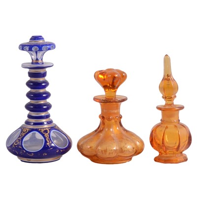 Lot 1186 - Three glass perfume bottles, two amber and one cased Bristol blue.