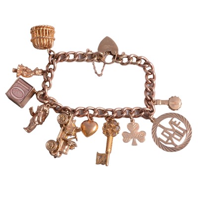 Lot 291 - A rose metal charm bracelet with ten charms attached.