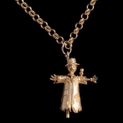 Lot 414 - A 9 carat yellow gold scarecrow pendant and chain.