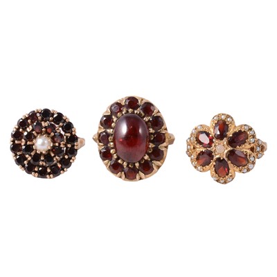 Lot 28 - Three 9 carat yellow gold vintage garnet dress rings.