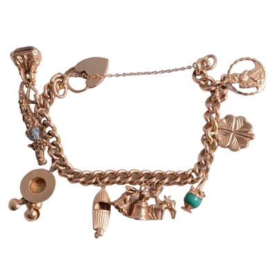 Lot 292 - A gold charm bracelet with nine charms attached.
