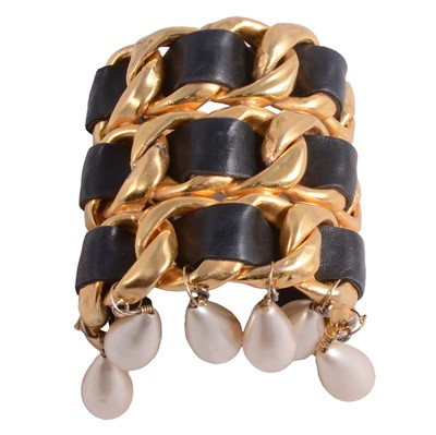Lot 1193 - Chanel - a vintage triple row chain and leather dangle cuff bangle.