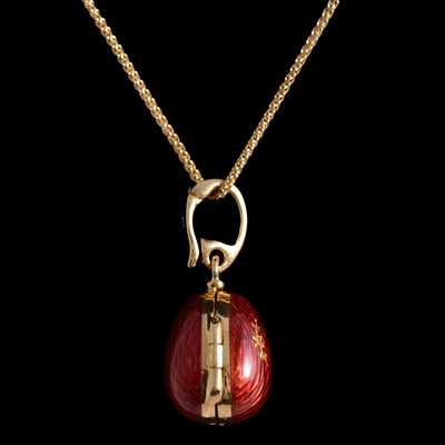 Lot 409 - Victor Mayer for Fabergé – an 18 carat yellow gold and red enamel egg pendant, and two chains.