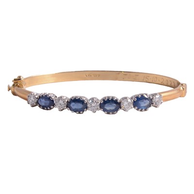 Lot 274 - A sapphire and diamond half-hinged bangle.