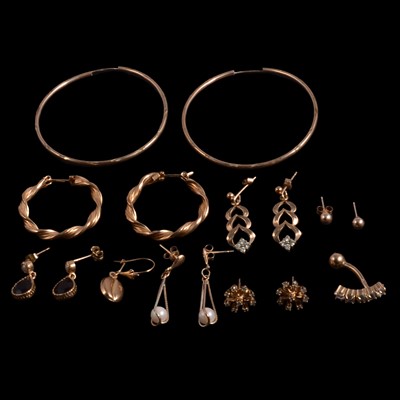 Lot 452 - Seven pairs of gold / yellow metal earrings, a single earring, and a piercing.