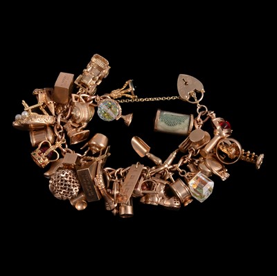 Lot 253 - A 9 carat yellow gold charm bracelet with charms attached.