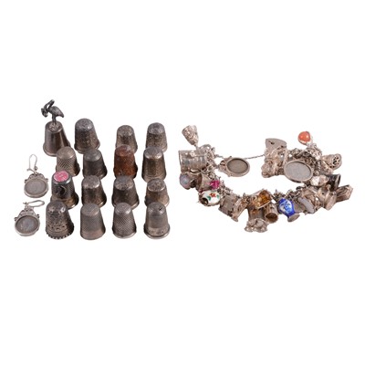 Lot 519 - A silver charm bracelet with charms attached, thimbles, and a pair of coin set earrings.