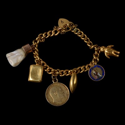 Lot 254 - A yellow metal charm bracelet with charms.