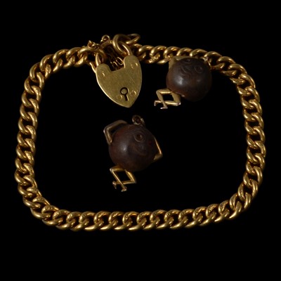 Lot 257 - A yellow metal curb link bracelet with "Touch Wud" charms.