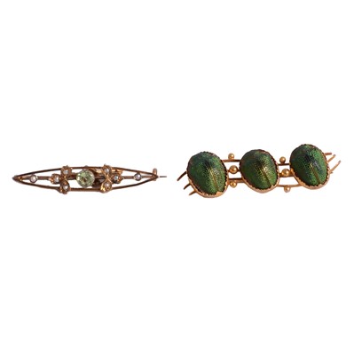 Lot 226 - A scarab brooch and a peridot brooch.