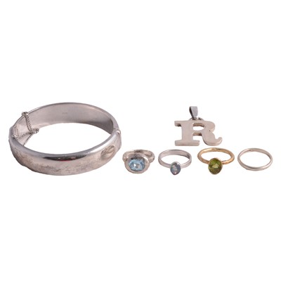 Lot 517 - A silver half hinged bangle, 9 carat gold wedding band, initial R pendant, and three rings.