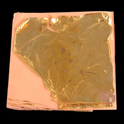 Lot 152 - A folder of gold leaf and two white metal discs testing as silver.
