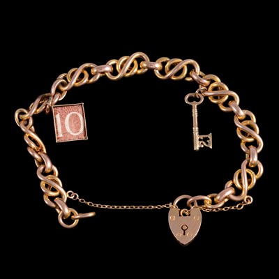 Lot 256 - A yellow and rose metal charm bracelet with charms attached.