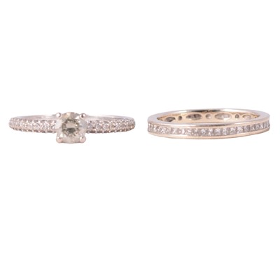 Lot 77 - A diamond full eternity ring, and a diamond solitaire ring with diamond set shoulders.