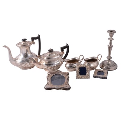 Lot 175 - Three silver-mounted photograph frames, silver-plated candlesticks, teaset, and metal fish eaters.