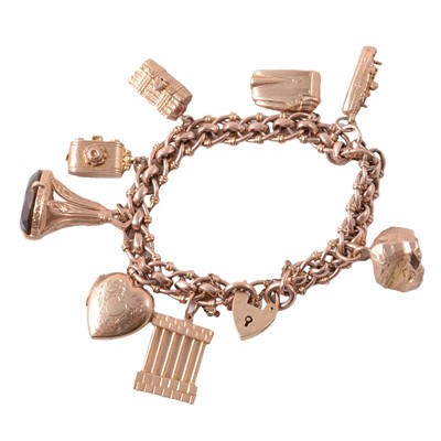 Lot 170 - A rose metal fancy link bracelet with padlock fastener and eight charms.