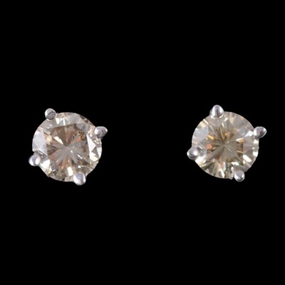 Lot 250 - A pair of diamond solitaire stud earrings.