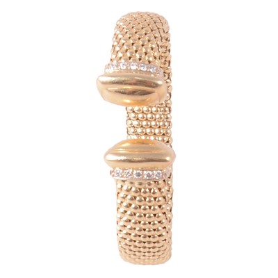Lot 163 - A yellow metal Caviar design torque bangle set with synthetic white stones.