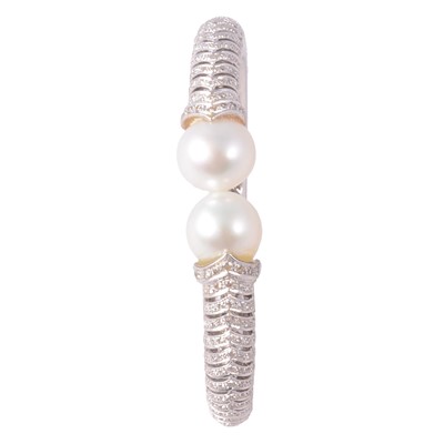 Lot 161 - A diamond and pearl half hinged bangle.