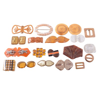 Lot 417 - Twenty early plastic, mother-of-pearl, glass, and wooden buckles in orange and brown tones.