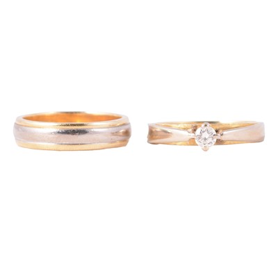Lot 56 - An 18 carat yellow and white gold solitaire diamond ring and wedding band.
