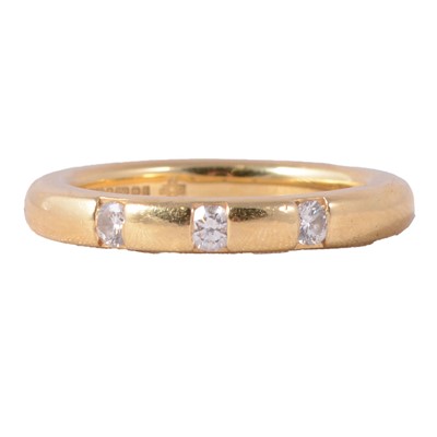 Lot 62 - An 18 carat yellow gold band set with three diamonds.