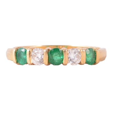 Lot 21 - Fred E Ullmann - an emerald and diamond half hoop ring.