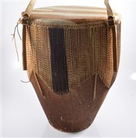Lot 574 - A hide covered tribal drum, with strap,...