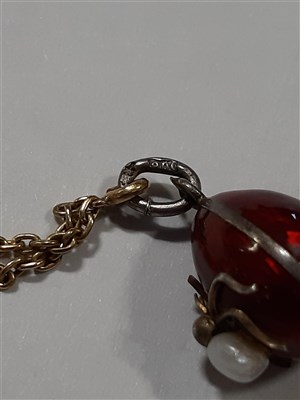 Lot 265 - A Russian yellow metal charm necklace, with two pendants and a locket by Fabergé